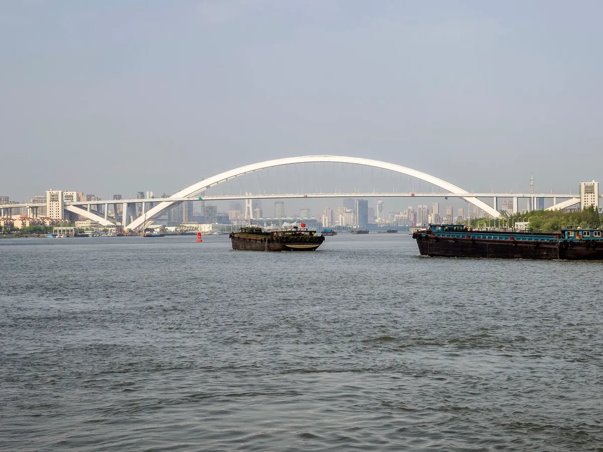 Breathtaking view of Lupu Bridge with ships on the Huangpu River in Shanghai, China.