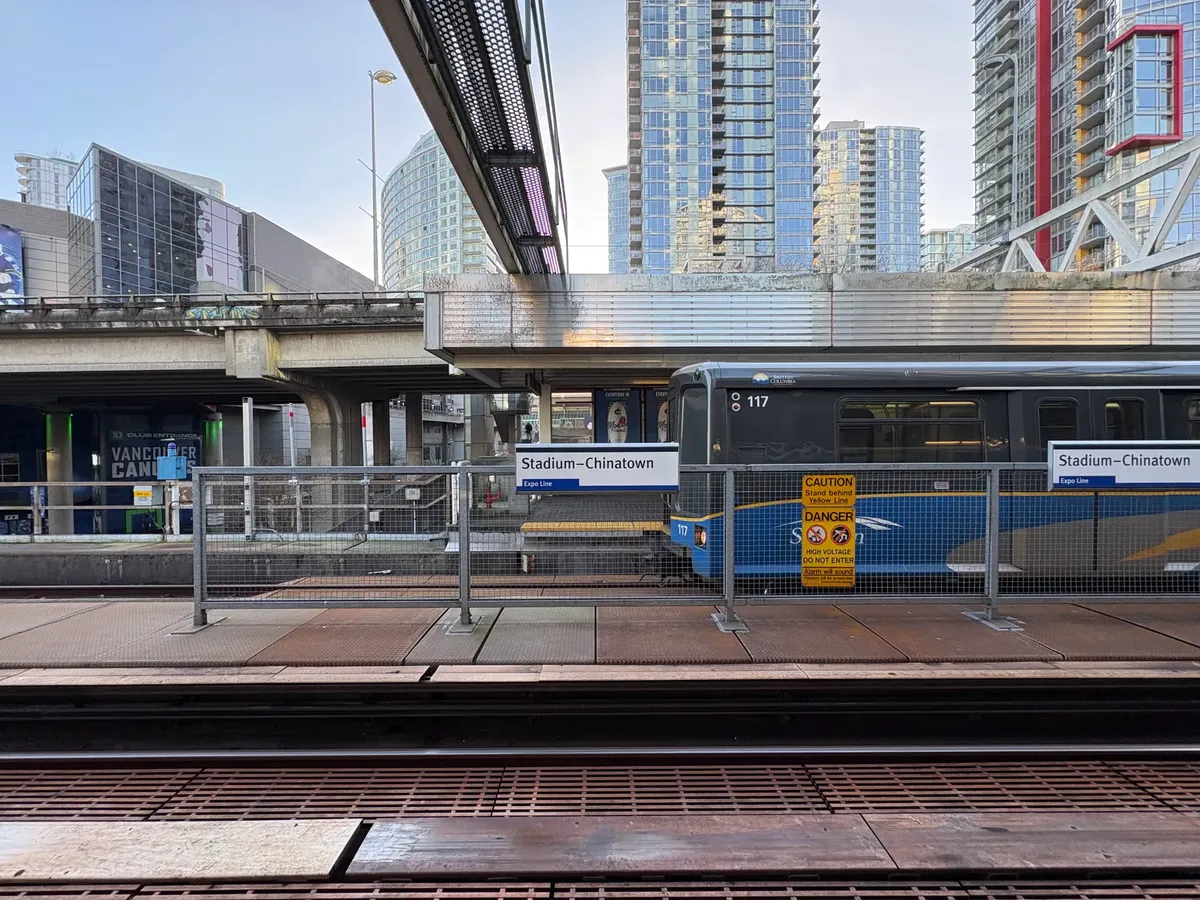 SkyTrain in Vancouver at Stadium-Chinatown station with modern cityscape backdrop.